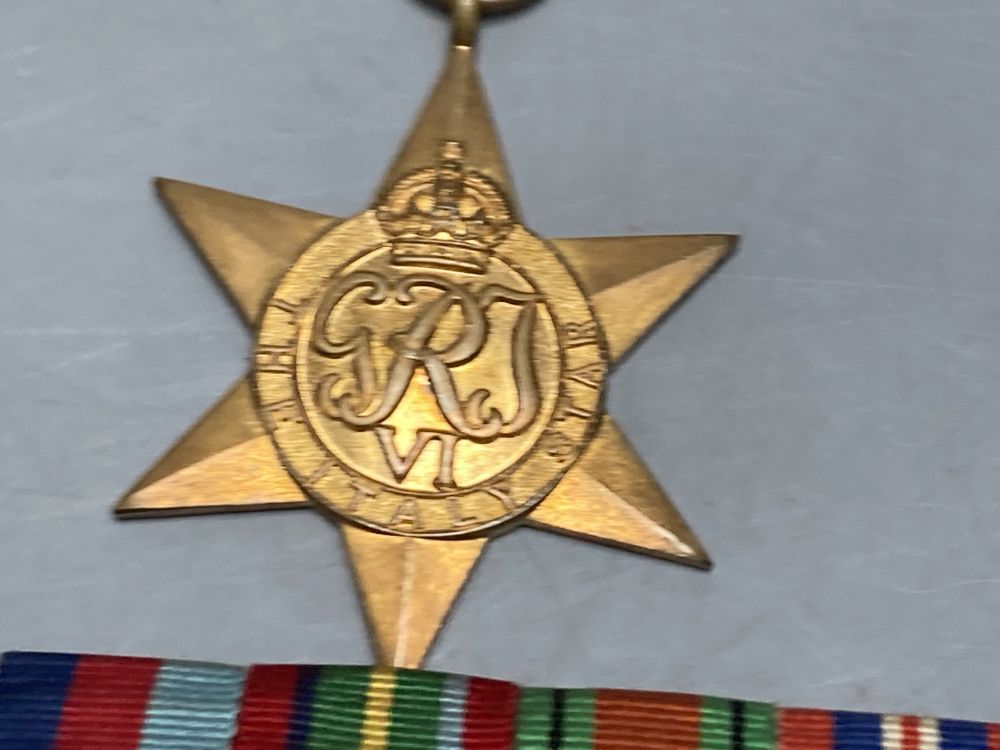 A WWII trio and a WWI pair, a collection of cap badges and non matching WWII miniatures